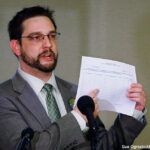 Micah Gamino, a Green Party representative for the group Oklahomans for Ballot Access Reform, gestures as he displays a copy of a petition form at a news conference Oklahoma City, Monday, June 15, 2015, where the Libertarian and Green parties in Oklahoma announced plans to launch signature drives to have their parties and candidates officially recognized in Oklahoma.