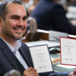 California Electoral College member Benjamin Cardenas displays his ballots to television cameras after casting his votes for president and vice president at the Capitol in Sacramento on December 19, 2016.