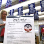 In this March 1, 2016, file photo, a sign tells voters of voter ID requirements before participating in the primary election at Sherrod Elementary school in Arlington, Texas. Attorneys challenging tough voter ID laws in Texas and North Carolina say they¿ll keep pressing their lawsuits without the support of President Donald Trump¿s Justice Department if necessary. Trump announced Wednesday, Jan. 25, 2017, that he is ordering a ¿major investigation¿ into voter fraud, which tough laws requiring photo identification at the ballot box are designed to prevent.