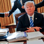 President Donald Trump sits at his desk after a meeting.