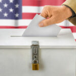 Man putting a ballot into a voting box – USA