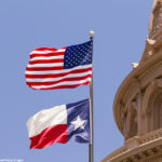 US and Texas flags flying over Texas State Capitol building, Austin