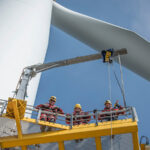 Three engineers on a wind turbine at an offshore windfarm.