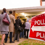 voters standing in line outside of a polling location